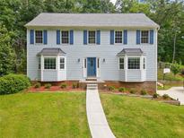 Charming two-story home with light blue siding, blue shutters, bay windows, and a well-manicured front lawn at 4197 Chadds Xing, Marietta, GA 30062