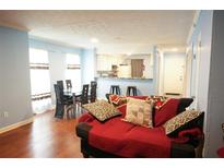 Inviting living room featuring a comfortable red sofa, an open kitchen, and a dining area with a black table and chairs at 852 Glynn Oaks Dr, Clarkston, GA 30021