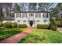 Charming two-story home with a brick pathway, beautiful lawn, and well-maintained landscaping at 2955 Rhodenhaven Nw Dr, Atlanta, GA 30327