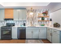 Charming kitchen featuring light blue cabinets, modern appliances, light wood accents and decorative shelving at 666 Serramonte Drive Dr, Marietta, GA 30068