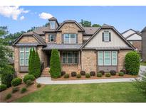 Charming brick home with manicured lawn, tasteful landscaping, and inviting front entry offers great curb appeal at 8920 Ellesmere Dr, Cumming, GA 30041