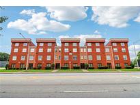 Apartment building with multiple units, manicured landscaping, and a bright blue sky at 2465 Main St # 201, Atlanta, GA 30344