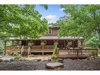 Charming log cabin featuring a spacious wooden deck, perfect for enjoying the outdoors at 521 E East Valley Road Northeast Ne Rd, Rydal, GA 30171