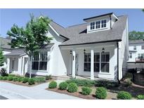 Charming two-story home featuring white siding, a covered front porch, and professionally landscaped yard at 992 Harvest Park Ln, Suwanee, GA 30024