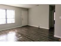 Spacious living room featuring wood-look flooring and a bright window, perfect for natural light at 2566 Stratford Ln, Morrow, GA 30260