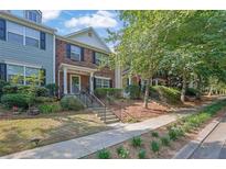 Charming townhomes with brick accents, manicured lawns, and welcoming front entrances at 833 Society Ct, Woodstock, GA 30188