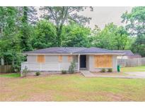 Charming single-story home with a covered front porch and a well-maintained lawn at 1421 Dennis Dr, Decatur, GA 30032