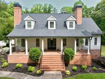 Charming two-story home featuring a brick foundation, inviting front porch with classic columns, and well-manicured landscaping at 5588 Rhododendron Trl, Douglasville, GA 30135
