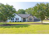 Charming single-story home with stone accents, well-maintained lawn, and mature trees at 1510 Summer Lake Ter, Loganville, GA 30052