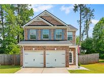Charming two-story brick home with a two-car garage and neatly landscaped front yard at 154 Stephens Mill Dr, Dallas, GA 30157