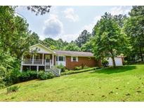 Charming single-Gathering home with a brick facade, inviting front porch, and a lush green lawn at 3223 Heritage Way, Buford, GA 30519