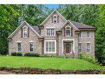 Charming brick home featuring a manicured lawn, mature trees, and a welcoming facade at 1548 Valley Reserve Court, Kennesaw, GA 30152
