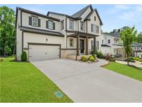 Beautiful two-story home with a two-car garage, manicured lawn, and welcoming front porch at 382 Tillman Pass, Woodstock, GA 30188