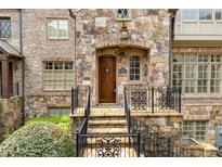 Charming stone exterior with a wooden front door and decorative iron railings at 4853 Stonehall Pl, Atlanta, GA 30339