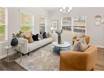 Bright living room features large windows, modern furniture, and stylish decor at 1346 Riverstone Rd # 107, Jonesboro, GA 30238