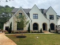 Stunning two-story home featuring white brick, stone accents, arched entryways and a meticulously landscaped front yard at 344 Michael Dr, Alpharetta, GA 30009