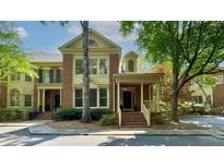 Charming brick townhome featuring a welcoming entrance, front porch, and manicured landscaping at 2010 Riverside Rd, Roswell, GA 30076