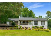 Charming home featuring a front porch and landscaped yard with mature trees at 117 Franklin Rd, Woodstock, GA 30188