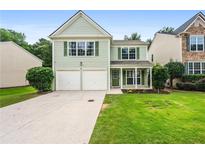 Charming two-story home with a well-manicured lawn, a two-car garage, and a welcoming front porch at 186 Wallnut Hall Cir, Woodstock, GA 30189