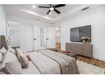Bright bedroom with a ceiling fan, ensuite bath, and a large TV at 904 Fairburn Nw Pl, Atlanta, GA 30331