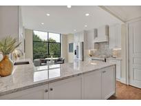 Bright kitchen features white cabinets, granite countertops, stainless steel appliances, and a breakfast nook with a view at 750 Park Ne Ave # 6E, Atlanta, GA 30326