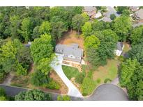 Beautiful home with a well-manicured lawn and a long driveway surrounded by lush trees at 3702 Running Fox Dr, Marietta, GA 30062