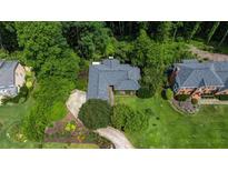 An aerial view of the home showcasing its mature landscaping and a private driveway leading to the property at 11785 Mountain Laurel Dr, Roswell, GA 30075