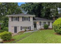 Charming home with brick facade, complemented by a lush green lawn and mature trees at 2083 Green Forrest Dr, Decatur, GA 30032