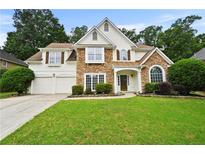 Charming two-story home featuring stone accents, a well-manicured lawn, and a two-car garage at 4360 Canterbury Walk Dr, Duluth, GA 30097