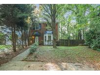 Charming brick home featuring a well-maintained front yard and mature trees at 1417 Poplar Pointe Se, Smyrna, GA 30082