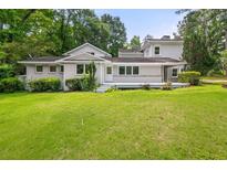 Expansive backyard featuring lush lawn, mature trees, and a charming back deck for outdoor living at 6771 Sunny Brook Ln, Atlanta, GA 30328