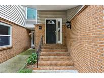 Charming townhouse entrance with brick steps leading to a black front door at 85 Dunwoody Springs Dr, Sandy Springs, GA 30328