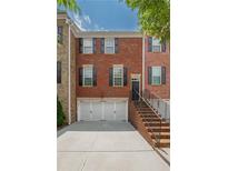 Charming brick townhome with a two-car garage, black shutters, and a well-maintained brick stair entry at 2264 Ewell Park Dr, Lawrenceville, GA 30043