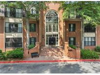 Charming brick condo building with a large arched window above the double door entryway and manicured landscaping at 23307 Plantation Ne Dr, Atlanta, GA 30324