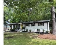 Charming white brick home featuring a well-manicured lawn and a striking yellow front door at 4396 Greenleaf Cir, Atlanta, GA 30331