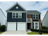 Charming two-story home featuring a two-car garage and a mix of brick and blue siding at 535 Watercress Dr, Woodstock, GA 30188