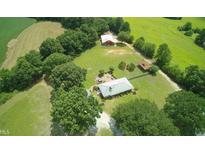 Expansive property featuring a primary home and a secondary structure surrounded by lush greenery and open fields at , Social Circle, GA 30025