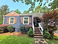 Charming blue house with a quaint front porch and well-maintained landscaping at 3226 Hope St, Hapeville, GA 30354