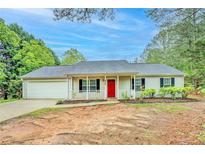 Charming single-story home with a red front door and a well-maintained front yard at 4547 Atha Cir, Loganville, GA 30052