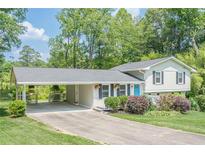 Charming two-story home with carport, manicured lawn, and mature trees create a welcoming curb appeal at 205 Plantation Sw Rd, Smyrna, GA 30082