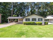 Charming single-story home with a well-manicured lawn and attached carport at 1749 W Caribaea Se Trl, Atlanta, GA 30316