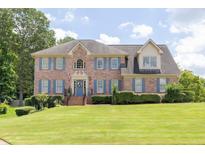 Charming two-story brick home featuring blue shutters and a well-manicured lawn at 3574 Timberloch Trl, Snellville, GA 30039