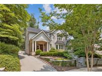 Charming stone home with manicured front yard, columns, and inviting entryway at 54 Camden Ne Rd, Atlanta, GA 30309