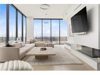 Bright living room featuring floor-to-ceiling windows and a modern fireplace beneath a large flat screen TV at 788 W Marietta St # 1809, Atlanta, GA 30318