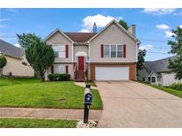 Charming two-story home with red shutters, two-car garage, green lawn, and inviting red front door at 335 Lee Miller Ct, Suwanee, GA 30024