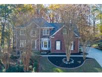 Charming brick home boasts a well-manicured lawn and classic architectural details at 2001 Towne Lake W Hls, Woodstock, GA 30189