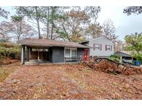 Charming split level home with red door, painted brick and a covered side entrance at 2475 Harvel Nw Dr, Atlanta, GA 30318