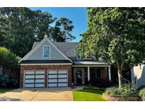 Charming brick home with a well-manicured lawn, featuring a two-car garage, inviting front porch, and mature trees at 81 Richmond Way, Villa Rica, GA 30180