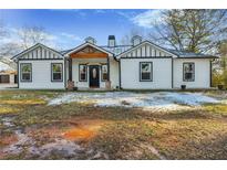 Charming renovated one-story home with a black and white exterior and a wood-framed front porch at 2711 Mcdonough Rd, Hampton, GA 30228