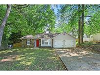 Charming single-story home featuring a stone facade, attached garage, and bright red front door at 971 Clover Ln, Lawrenceville, GA 30044